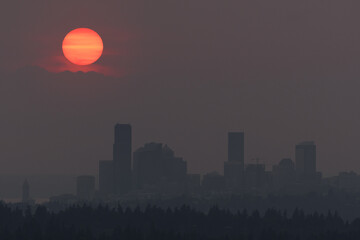 Heavy wildfire smoke surrounds Seattle with sunset behind the Olympic Mountains
