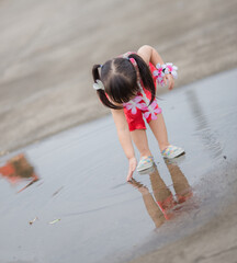 Close-up background view of a blurred Asian girl running or teasing in the street in front of the...