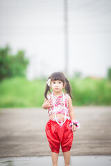 Naklejka premium Close-up background view of a blurred Asian girl running or teasing in the street in front of the house, doing activities together outside the classroom during the holidays.
