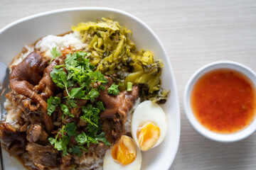 Top view of pork stew with boiled eggs over rice and sauce on the si