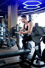 Strong handsome man in gym. Attractive male in sportswear working out.