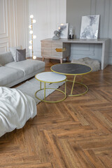 minimalistic interior of an ultra modern open plan apartment with white and gray walls with a relief and gray stylish upholstered furniture and huge windows