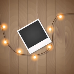 Photo frame with christmas lights on wooden background Vector