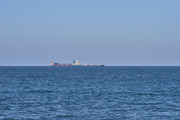 Beautiful evening view of cargo and container ships in the Irish Sea seen from West Pier of Dun Laoghaire harbor, Dublin, Ireland. Soft and selective focus. Minimalism