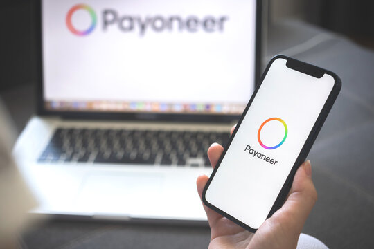 Kharkov, Ukraine - August 12, 2021: New Payoneer app. Woman using smartphone with payoneer application. Brand logo photo
