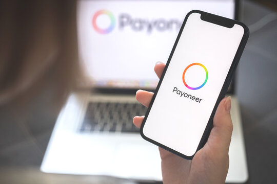 Kharkov, Ukraine - August 12, 2021: New Payoneer app. Woman using smartphone with payoneer banking application. Brand logo photo