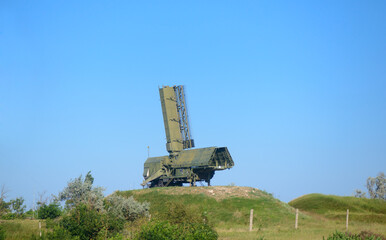 Radar station with antenna on a hill on a sunny summer day