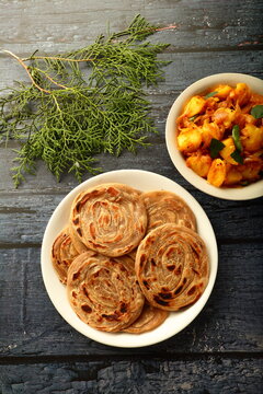 North Indian recipes- homemade wheat paratha, porota, porotta with spicy cooked aloo paneer dish. healthy vegetarian cuisine.