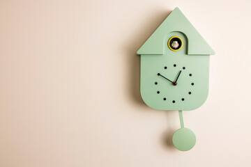 Close up view of grey wall cuckoo clock on pink background. Sweden.