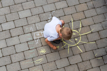 Beautiful top-down view on child drawing with chalk on paving slabs. Sweden. 