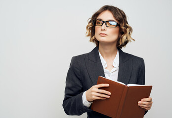 woman in business suit with a book in his hands isolated background