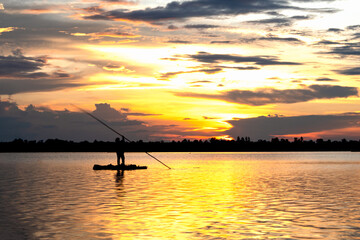 silhouette of fisherman rowing boat in the time sunset