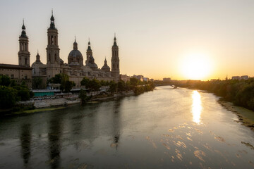 View of Nuestra Señora del Pilar from the stone bridge at sunset on a hot summer day in Zaragoza.