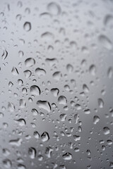 Water drops on the glass. The transparent surface of the glass is covered with drops of rainwater. Nostalgic background.