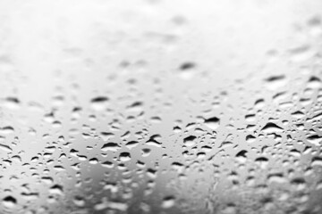 Water drops on the glass. The transparent surface of the glass is covered with drops of rainwater. Nostalgic background.