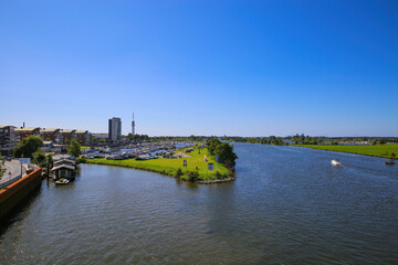 Roermond (Marina Oolderhuske), Netherlands - July 9. 2021: View on harbor with motor boats and sail yachts against blue summer sky, citiyscape and river maas background