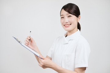 カルテに記入する白衣の女性 
