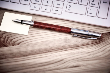 Wooden desk office with pc cayboard, and other work supplies. Top view with copy space for input the text. Designer workspace on desk table essential elements on flat lay