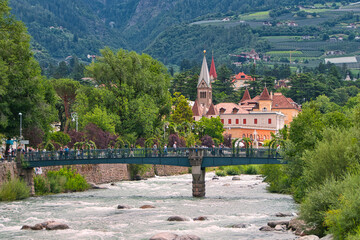 Fototapeta premium Die Thermenbrücke über der Passer in Meran mit Kirche im Hintergrund