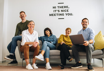 Happy executives sitting together on sofa