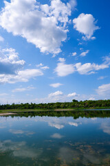 Naklejka na ściany i meble Beautiful summer landscape. Sky, clouds, lake. Mirror the sky and trees in the lake. Good screensaver or wallpaper.