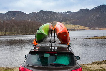 Kayaks ready to launch onto a lake in Norway with Mountains in the background