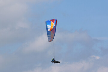 	
Paraglider in a blue sky