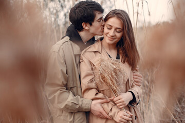 Beautiful couple spend time in a autumn field