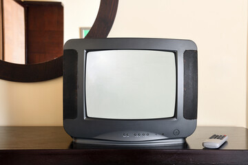An old black TV is on the bedside table in the apartment. Vintage TVs 1980s 1990s 2000s.