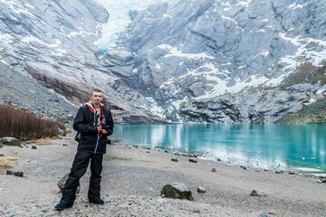 Naklejka premium Tourist at amazing Briksdalsbre Briksdalsbreen glacier in the winder Norway.