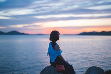 夕暮れの海の女性