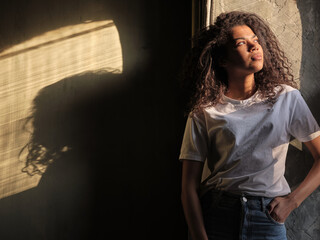 Fototapeta premium mixed race african girl sitting near window and do enjoy the sunlight