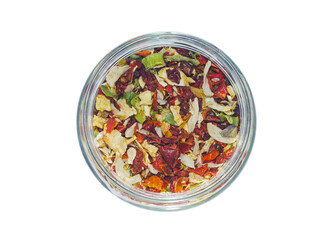 Sliced  dried vegetables in a round transparent glass jar. View from above. Isolated on white background. Condiments and spices.