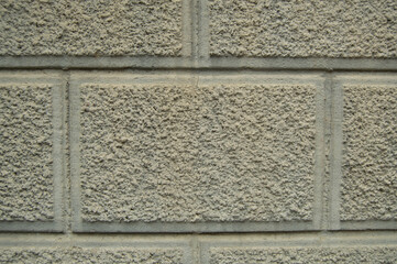 Gray, uneven wall, in the form of panels, made of concrete. Background, texture
