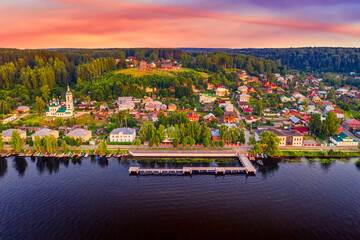 Fototapeta premium Aerial drone view of ancient russian town Ples on the Volga river with colorful sunset