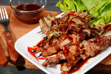 Barbecue or mala pork and mushrooms, bacon in a plate on a wooden cutting board