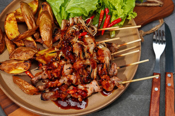 Barbecue or mala pork and mushrooms, bacon in a plate on a wooden cutting board