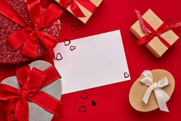 Various choices gift box in the form of heart with a red ribbon on a red background. Valentines day concept postcard. Top view flat lay with copy space.