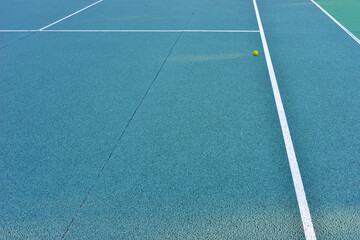Terrain de tennis en Quick bleu et sa balle jaune égarée
