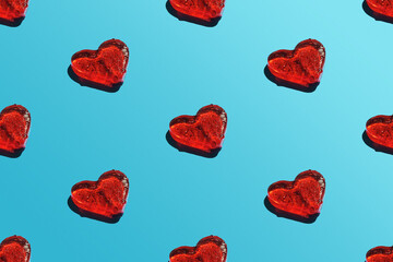 A repeating heart pattern on a blue background with a sharp shadow.