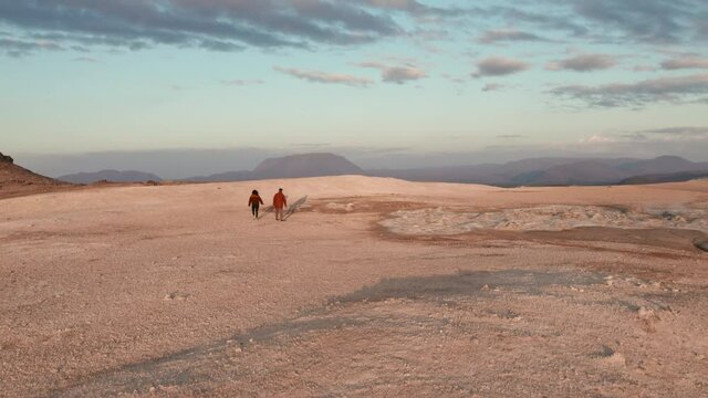 Two Tourists Walking in the Vast Geothermal Field in the Background