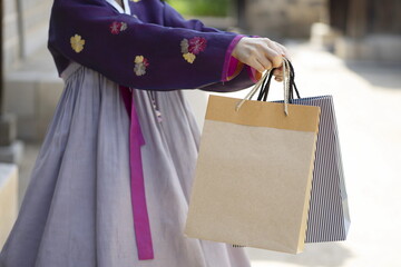 Woman in Korean traditional clothes holding shopping bags
