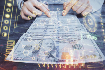 Double exposure of technology drawing hologram and us dollars bills and man hands. Data concept