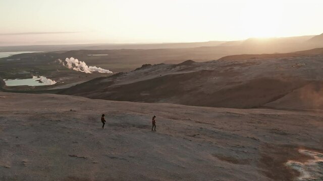 Couple Walking on Geothermal Area in Iceland With Landscape of Beautiful Skies