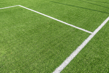 Obraz premium Soccer football background. Green synthetic artificial grass soccer sports field with white stripe lines