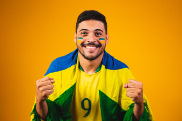 brazilian fan cheering in the crowd on yellow background. - obrazy, fototapety, plakaty