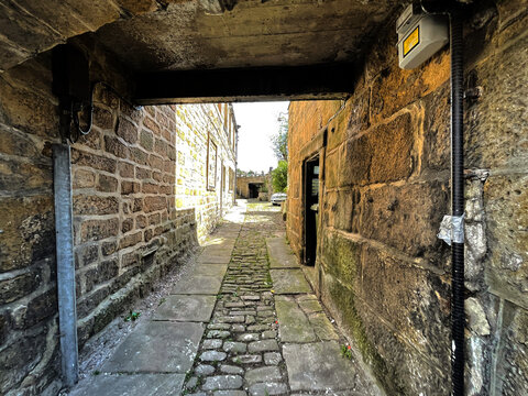 Old stone cobbled alleyway, leading from the, High Street in, Pateley Bridge, Harrogate, UK