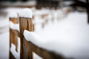 Several inches of snow collects on top of a wooden split rail fence on a cold winter day in Bailey, Colorado.