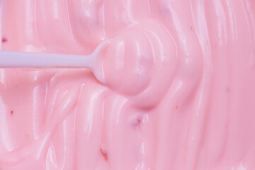 Macro Yogurt,Strawberry frozen yogurt background close up. Strawberry ice cream texture close up. Top view. Pink fruit ice cream background with small pieces of berries