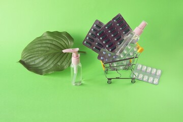 Toy trolley with various pills and capsules, spray on a bright background with copy space, the concept of medicine, pharmacy, drug delivery, sales
